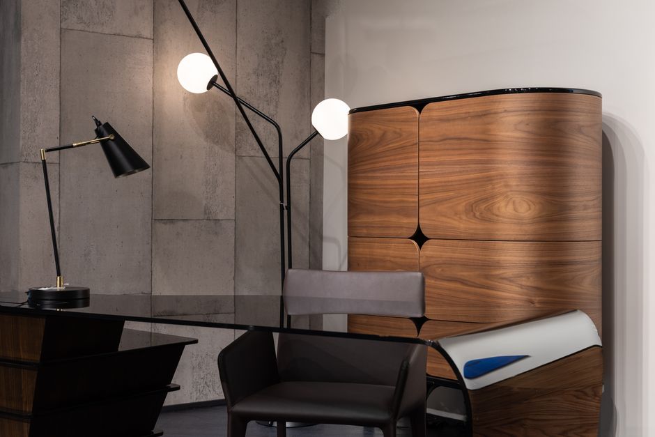Decisões da Presidência — Black desktop with comfortable chair placed at wall with wooden cupboard and glowing lamps in