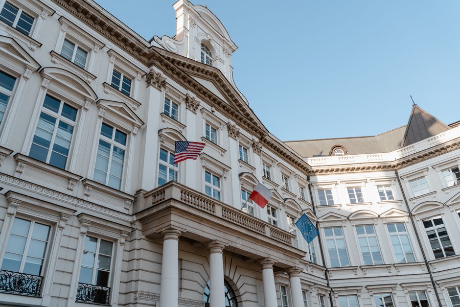 Decisões da Presidência — Low angle shot of a historic building with flags in an urban European district.